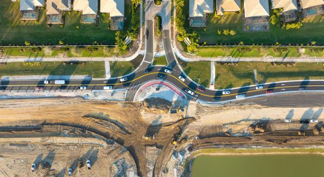 La cesión obligatoria de viales de interconexión de un municipio se consideran operaciones sujetas y no exentas de IVA. Imagen desde el cielo de la carretera en obras de una ciudad