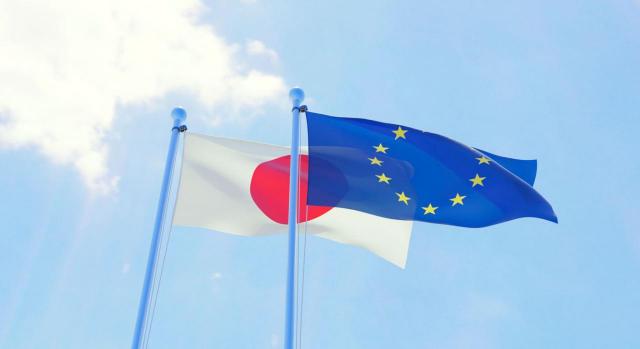 Acuerdo de asociación estratégica entre la Unión Europea y sus Estados miembros y Japón. Banderas de Japón y la Unión Europea ondenando sobre cielo azul