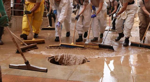 Primera consulta de la DGT relacionada con la DANA. Imagen de esfuerzo de equipo limpiando de barro las calles por los efectos de la DANA