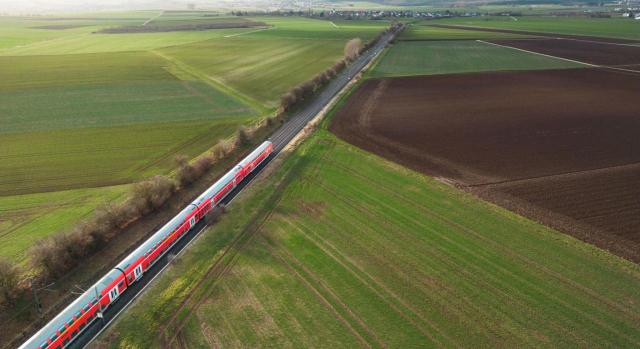 Cómputo del período de generación del incremento de valor para determinar la base imponible del IIVTNU. Imagen desde el cielo de un tren pasando por un prado